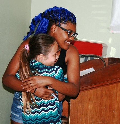 Tyanna Jones, a student at Westside High School, hugs 10-year-old Cynthia Mendoza.