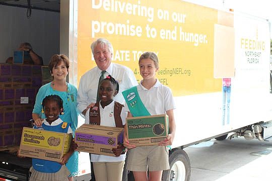 From left, Girl Scouts Chayana Payton, Kellie Ricks and Taryn McCormick with Mary Anne Jacobs, CEO of Girl Scouts of Gateway Council, and Bruce Ganger, president and CEO of Feeding Northeast Florida.