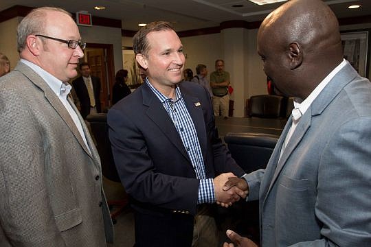 Mayor Lenny Curry shakes hands with new City Council member Sam Newby, while fellow new councilman Scott Wilson looks on.