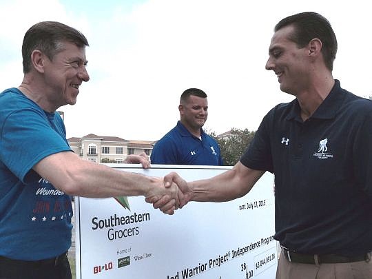 Southeastern Grocers CEO Ian McLeod shakes hands with Wounded Warrior Project Chief Executive Steve Nardizzi on Friday after presenting a check replica for $3,044,091.38 from donations collected in connection with the July 4 holiday. Wounded Warrior S...