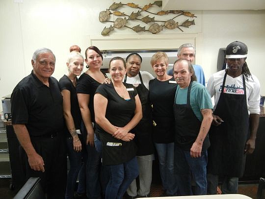 The team at Two Doors Down, from left, partner Norm Abraham, Charis Gilmore, Jinger Byram, Dottie Hodges, Daisy McLain, Martha Mathews, partner Enos "Whitey" White Jr., Bill Anderson and Robert Jean. Their collective experience in the business is 149 ...