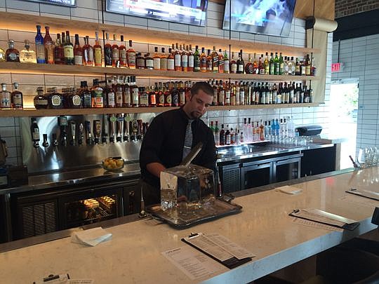 Bar manager Mike Everett demonstrates how ice will be carved for the Riverside restaurant's craft cocktails.