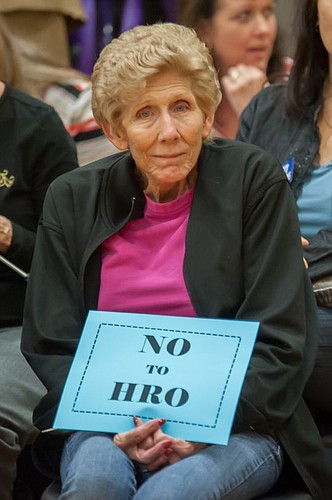 Barbara Newman holds a sign showing her opposition to expanding the ordinance.