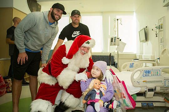 After receiving a new doll, 6-year-old Melanie warms up quickly to Santa Claus and his helpers, Jaguars quarterbacks Blake Bortles and Chad Henne. Patients at Wolfson Children's Hospital received surprise visits from Santa and several football players...