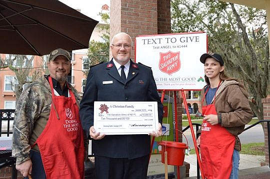 Maj. Rob Vincent, area commander of the Salvation Army of Northeast Florida, with volunteer bell ringers Billy and Nicole Worthington from Tom Nehl Truck Co. and a contribution from an anonymous donor.