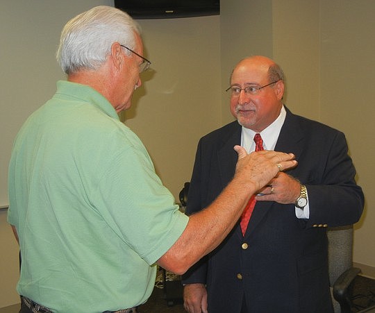 Photo by Karen Brune Mathis - Economics professor Paul Mason, (right) shown at one of his recent presentations, analyzes the local economy each quarter as director of the University of North Florida Local Economic Indicator Project.