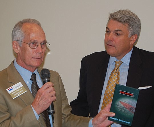 Photos by Max Marbut - At the group's meeting Friday, Downtown Council President Pat Geer presented a book, "Red Kayak" by Priscilla Cummings, to Jacksonville Port Authority CEO Paul Anderson, who inscribed it for donation to the library at Landon Mid...