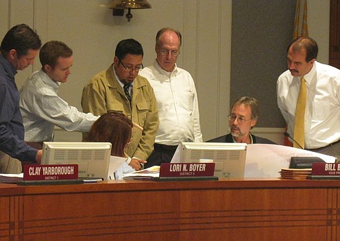 Photo by David Chapman - Soliman Salem (center) of the City's Planning and Development Department discusses a potential reapportionment map with City Council members during Thursday's special Rules Committee meeting. Council members Ray Holt, Clay Yar...