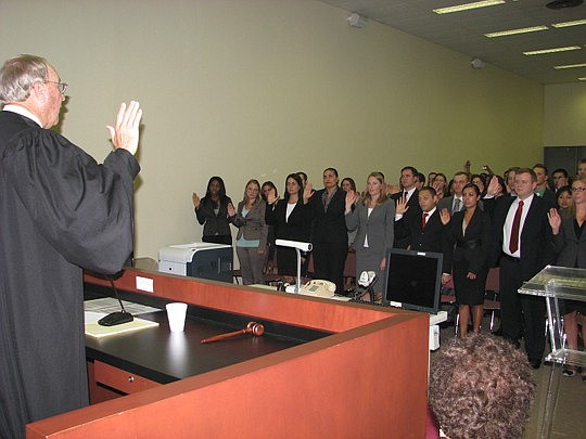 Photos by Joe Wilhelm Jr. - Circuit Judge David Wiggins swears in a group of about 100 new attorneys at the Duval County Courthouse annex Wednesday. Organizers didn't expect the number of attorneys, friends and family and moved the proceedings from th...