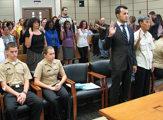 Photo by Joe Wilhelm Jr. - Fifty new citizens were sworn in at the Bryan Simpson U.S. Courthouse Thursday by U.S. Magistrate Judge Monte Richardson, who welcomed the culture and cuisine they brought from more than 30 different countries.