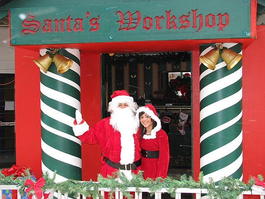 Photo by Joe Wilhelm Jr. - Santa and his helper Coraly are ready to welcome visitors to his workshop Friday at Adventure Landing on Beach Boulevard. The amusement park was transformed from a haunted mansion to a winter wonderland for its first Winterf...