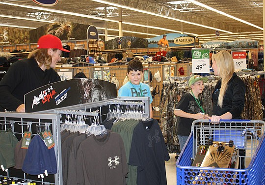 Photos by Joe Wilhelm Jr. - Gabbert and a member of the Roar accompany some Finegan Elementary students on a holiday shopping spree at Academy Sports and Outdoors after lunch at Winn-Dixie.