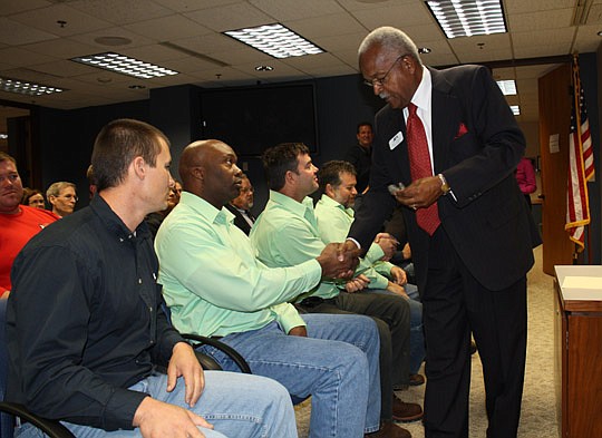 Photo by Joe Wilhelm Jr. - JEA board of directors Chairman Ron Townsend presents JEA troubleshooter Pat Banks with a pin Tuesday to thank him for participation in the 28th Annual International Lineman's Rodeo &amp; Expo in October. Board member Mike H...