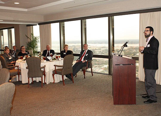 Photos by Joe Wilhelm Jr. - Innocence Project of Florida Executive Director Seth Miller (right) was the guest speaker at the Jacksonville chapter of the Federal Bar Association's "Spirit of Giving" lunch Dec. 16 at The River Club Downtown. Looking on ...