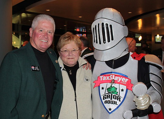 Photo by Joe Wilhelm Jr. - Past Gator Bowl Chairman Leerie Jenkins and his wife, Norma, with the TaxSlayer.com knight Tuesday.