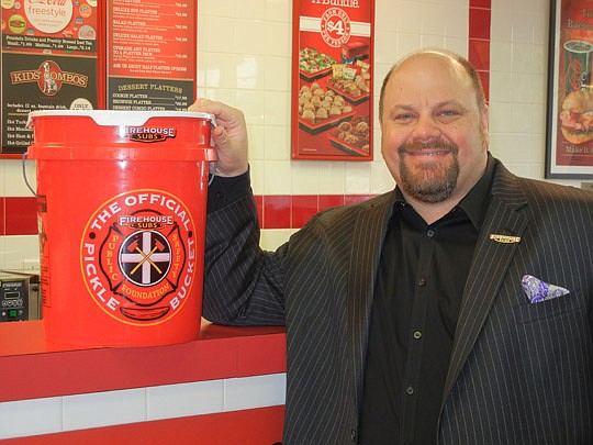 Photo by Karen Brune Mathis - Robin Sorensen and an empty 5-gallon pickle bucket. The empty buckets sell for $2 and the funds benefit the Firehouse Subs Public Safety Foundation, formed in 2005 to provide life-saving equipment to first responders as w...