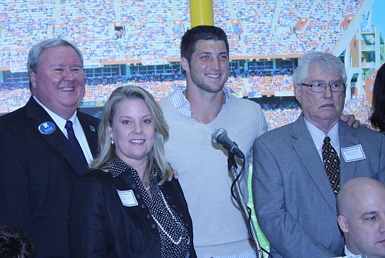 Photo by Joe Wilhelm Jr. - From left, Dreams Come True Executive Director Jimmy Kelly, board Vice President Heather Duncan, Tebow and board member Maylon Boatwright, who built and donated the Dreams Come True building at 6803 Southpoint Parkway in 200...