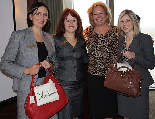 Photos by Joe Wilhelm Jr. - JWLA Secretary Kate Mesic, JWLA President Stephanie Harriett, guest speaker Valerie Logan and attorney Amelia Henderson at a meeting of the Jacksonville Women Lawyers Association at The River Club. The purses were given as ...