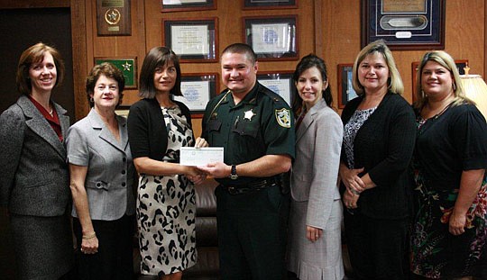 The Family Nurturing Center of Florida received a $10,000 donation from the Nassau County Sheriff's Office. From left are Valerie Faltemier, Elaine Coats, Stella Johnson, Capt. Butch Osborne, Chanda Rogers, Robin Hampton and Hope Lewis. Read the story...
