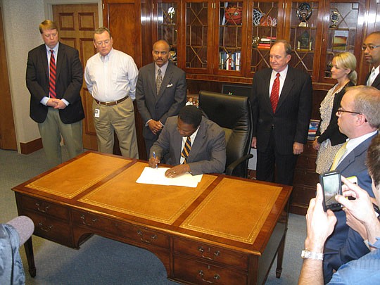 Photo by David Chapman - Surrounded by staff, Mayor Alvin Brown vetoes legislation approved by City Council that would appropriate $750,000 to purchase new furniture for hearing rooms on the seventh floor of the new Unified Duval County Courthouse. Th...