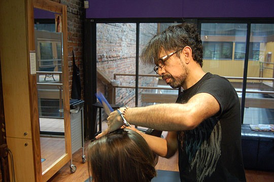 Stylist Carlos cuts a client's hair Monday during the "Cut-A-Thon for Community Connections" at Daniel James Aveda Hair Salon on West Bay Street Downtown. All the stylists donated their services to raise money to send children to summer camp. The proc...
