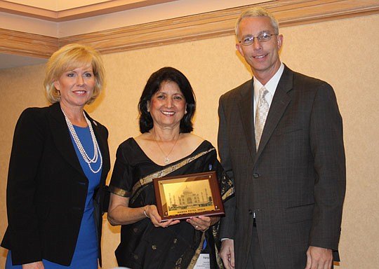 Photos by Joe Wilhelm Jr. - Hansa Patel (center), executive director for the All India Institute of Local Self Government-India, presents Sister Cities International Chairman Brad Cole and President-CEO Mary Kane with a gift at the opening session of ...