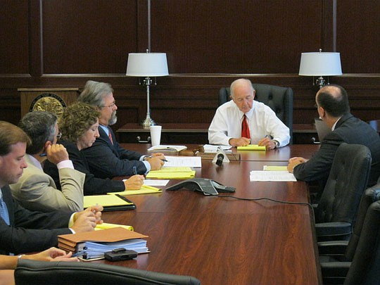 Photo by David Chapman - Senior Circuit Judge William Wilkes (center) discusses the City's suit against Jim Fuller with Mike Wedner (left), City deputy general counsel, and Lindsey Brock (right), representing Fuller. Wilkes set Aug. 7 as the hearing date.