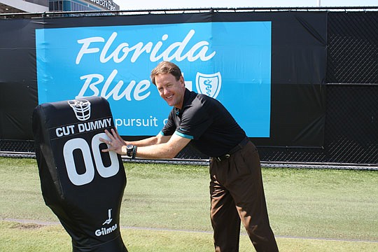 Photo by Joe Wilhelm Jr. - Scott Massey, Jacksonville Jaguars senior vice president of corporate partnerships, moves a tackling dummy from the Florida Blue sign at the Jaguars' Florida Blue Health and Wellness Practice Fields. He joined the Jaguars fr...