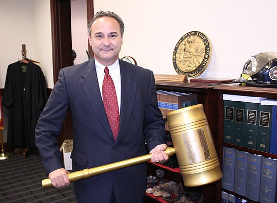 Photo by Joe Wilhelm Jr. - Duval County Court Judge Gary Flower holds a gavel given to him by former Florida Senate President John Mathews Jr. Flower says the oversized gavel is a symbol of walking softly but carrying a big stick. Flower is pictured i...