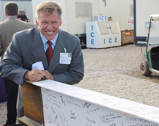Photos by Joe Wilhelm Jr. - St. Vincent's HealthCare President/CEO Moody Chisholm signs a beam Friday that will signal the completion of the first phase of construction on St. Vincent's Medical Center Clay County on Branan Field Road. Attendees of a "...