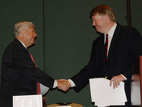 Photos by Joe Wilhelm Jr. - Former U.S. Sen. and Florida Gov. Bob Graham is welcomed to the podium by Mayor Alvin Brown's Chief of Staff Chris Hand Sept. 24 at The Jacksonville Bar Association meeting.