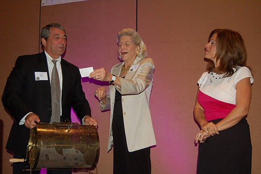Photo by Max Marbut - Financial News &amp; Daily Record Publisher Jim Bailey and his wife, Donna (right), assisted philanthropist Betsy Lovett as she drew the name of a not-for-profit that received a $1,000 donation from the Daily Record on Tuesday at...