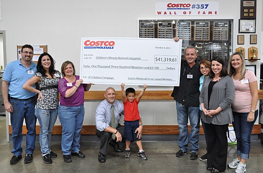 Costco associates present a check to benefit local pediatrics programs.