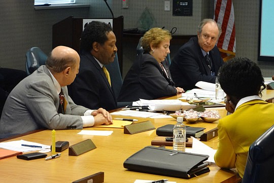 Photo by David Chapman - Jacksonville Aviation Authority board member Chester Aikens (second from left) comments on the board's performance review of authority CEO Steve Grossman (right) as board member Ernie Isaac and authority General Counsel Debra ...