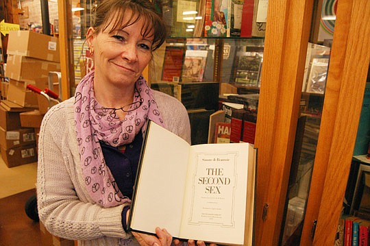 Photos by Max Marbut - Chamblin's Uptown manager Jennifer O'Donnell with a leather-bound first-edition copy of "The Second Sex" by Simone de Beauvoir. Originally published in 1949, it's signed by the author and part of the bookstore's collection of ra...