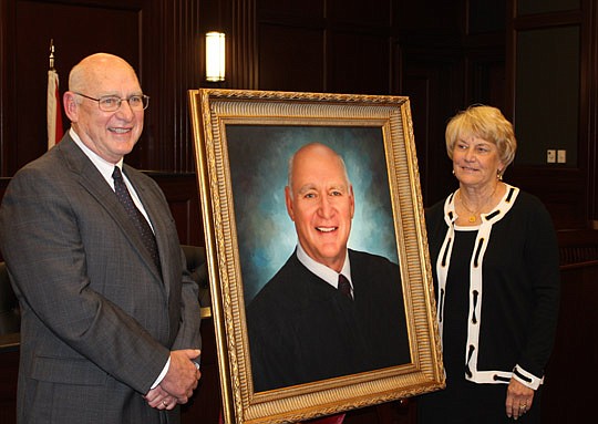 Photo by Joe Wilhelm Jr. - Circuit Court Judge Charles "Chuck" Arnold and his wife, Carolyn, with his portrait at his retirement ceremony Thursday at the Duval County Courthouse. He was appointed to the bench by Gov. Lawton Chiles in 1997.