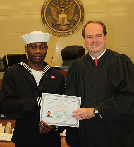 Photo by Joe Wilhelm Jr. - U.S. Navy Seaman Moses Aseda with U.S. District Judge Timothy Corrigan after Aseda was sworn in as a U.S. citizen Thursday at the Bryan Simpson U.S. Courthouse.