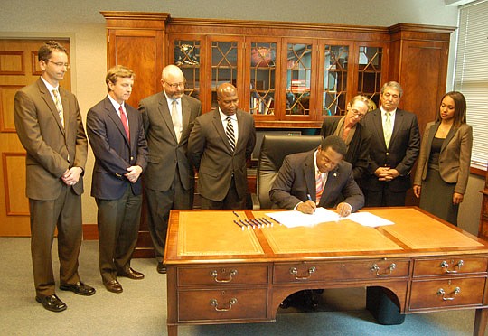 Photos by Max Marbut - Mayor Alvin Brown on Oct. 15 signed legislation that created the Downtown Investment Authority. Brown's signature was witnessed by DIA members (from left) Oliver Barakat, Rob Clements, Tony Allegretti, Donald Harris, Melody Bish...