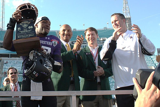 Photos by Joe Wilhelm Jr. - Northwestern University senior Jared Carpenter led the team in tackles with 10, which earned him the TaxSlayer.com Gator Bowl Most Valuable Player award. From left, Gator Bowl Association Chairman Fred Franklin, TaxSlayer.c...