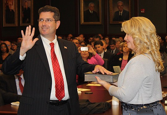 Photos by Joe Wilhelm Jr. - Circuit Court Judge Mark Borello is sworn in at Courtroom 406 of the Duval County Courthouse as his wife, Jacqueline, holds the bible.