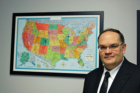 Photo by Laura Jane Pittman - Ben Warner, president and CEO of Jacksonville Community Council Inc., stands in front of a U.S. map with pushpins indicating cities where the nonpartisan civic organization has consulted since he came to the organization ...