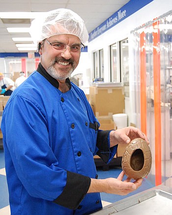 Photo by Laura Jane Pittman - Marty Lyp, plant manager and head chocolatier at Peterbrooke Chocolatier, holds the Wonder Egg - a hollow chocolate egg that will be filled with chocolate-covered popcorn. "We came up with this idea last year, looking for...