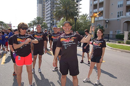Photos by Max Marbut - Jacksonville Sheriff's Office Director of Investigations and Homeland Security Mike Williams carried the flame Wednesday in the 2013 Law Enforcement Torch Run from the Police Memorial Building to the Landing.