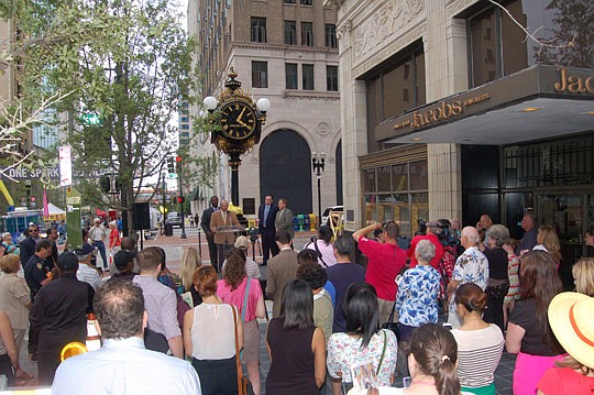 Photos by Max Marbut - One hour after the One Spark festival opened Wednesday, a crowd gathered along Laura Street for the rededication of the historic Seth Thomas clock at Jacobs Jewelers. Store owner Roy Thomas (at podium) was joined by Mayor Alvin ...