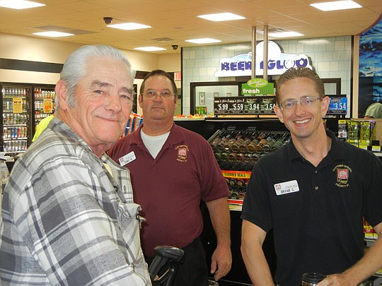 Dan Chenoweth (left) was the first customer at the new Gate store at 11040 McCormick Road when it opened at 6 a.m. today. He was served by store associates, including Tony Hale and store Manager Bryan Cake (right). Chenoweth lives nearby in the East A...