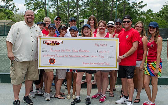 Firehouse Subs co-founders Robin and Chris Sorensen and Firehouse Subs staff display a check for more than $600,000, representing the proceeds from the 39th Annual Firehouse Subs Men's Doubles Tennis Tournament at Deerwood Country Club. The event bene...