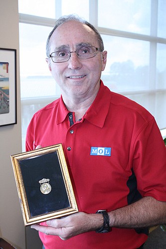 Photo by Joe Wilhelm Jr. - Dennis Kelly is the regional vice president and general manager of TraPac Inc., a shipping terminal operator at the Jacksonville Port Authority's Dames Point Marine Terminal. He holds a medal of appreciation given to his gra...