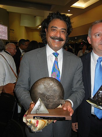 Photo by Karen Brune Mathis - Jacksonville Jaguars owner Shad Khan holds the Thompson S. Baker "Solid As A Rock" Award he was presented Thursday by Junior Achievement for his "embodiment of the American dream."