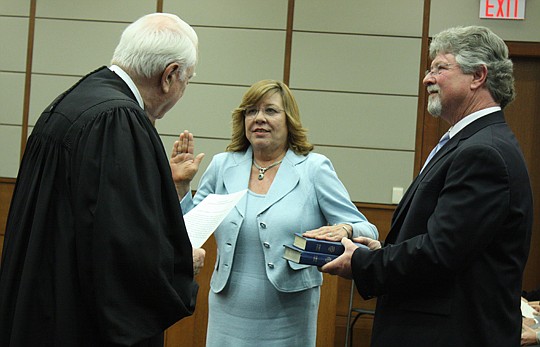 U.S. Court of Appeals Judge Gerald Tjoflat swears in U.S. Bankruptcy Court Judge Cynthia Carson Jackson on Friday at the Bryan Simpson U.S. Courthouse. Her husband, Dale, holds two Bibles - one from her father, former Jacksonville Sheriff Dale Carson,...