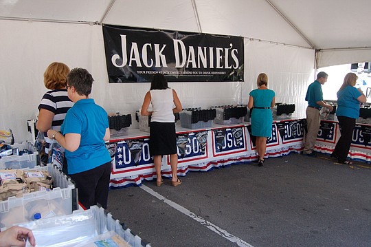 Photos by Max Marbut - Volunteers stuffed 7,500 care packages for U.S. military personnel Thursday at the Landing at "Toast for the Troops," a partnership between Jack Daniel's and the USO.